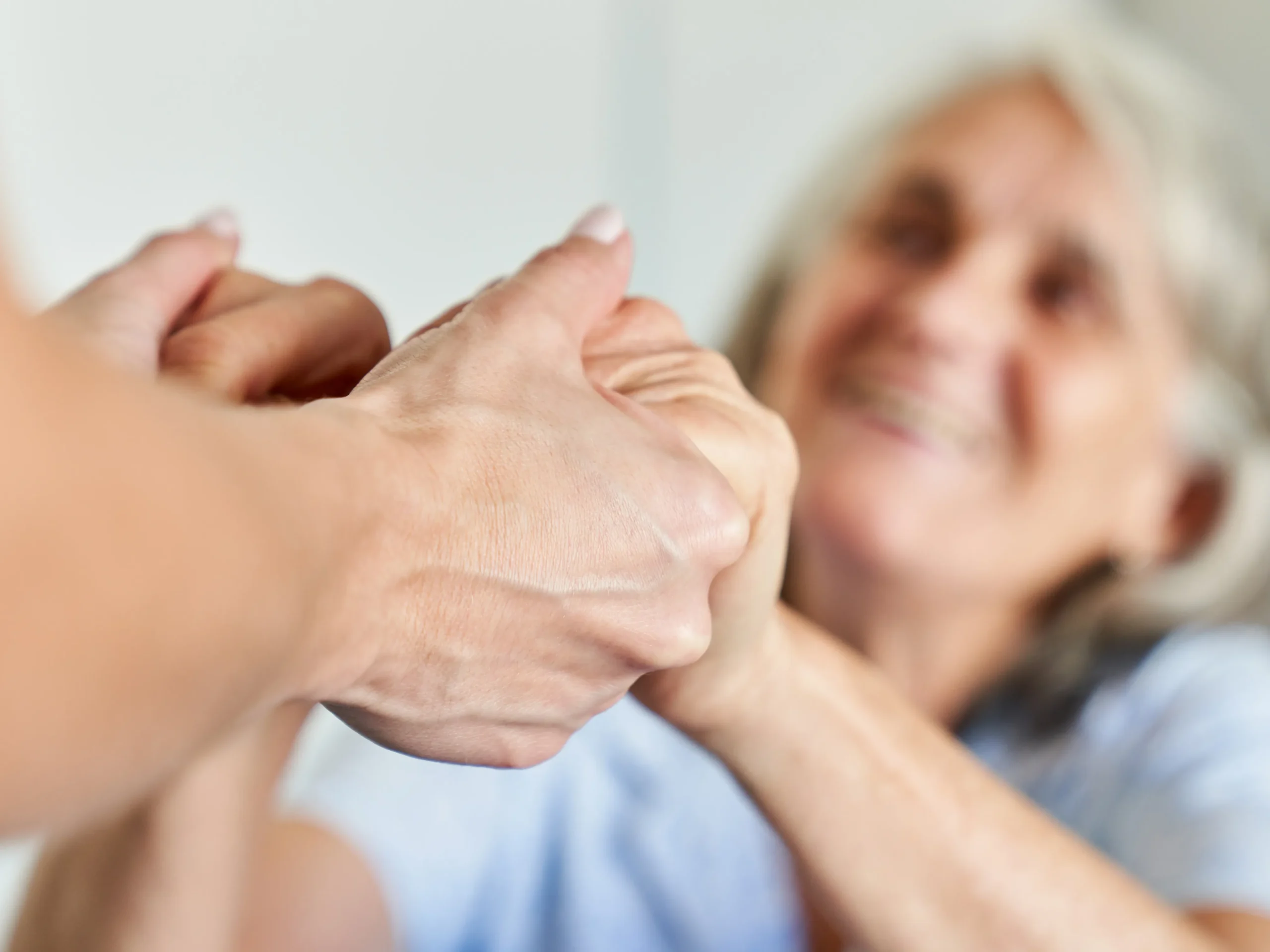 elderly woman holding someone's hands