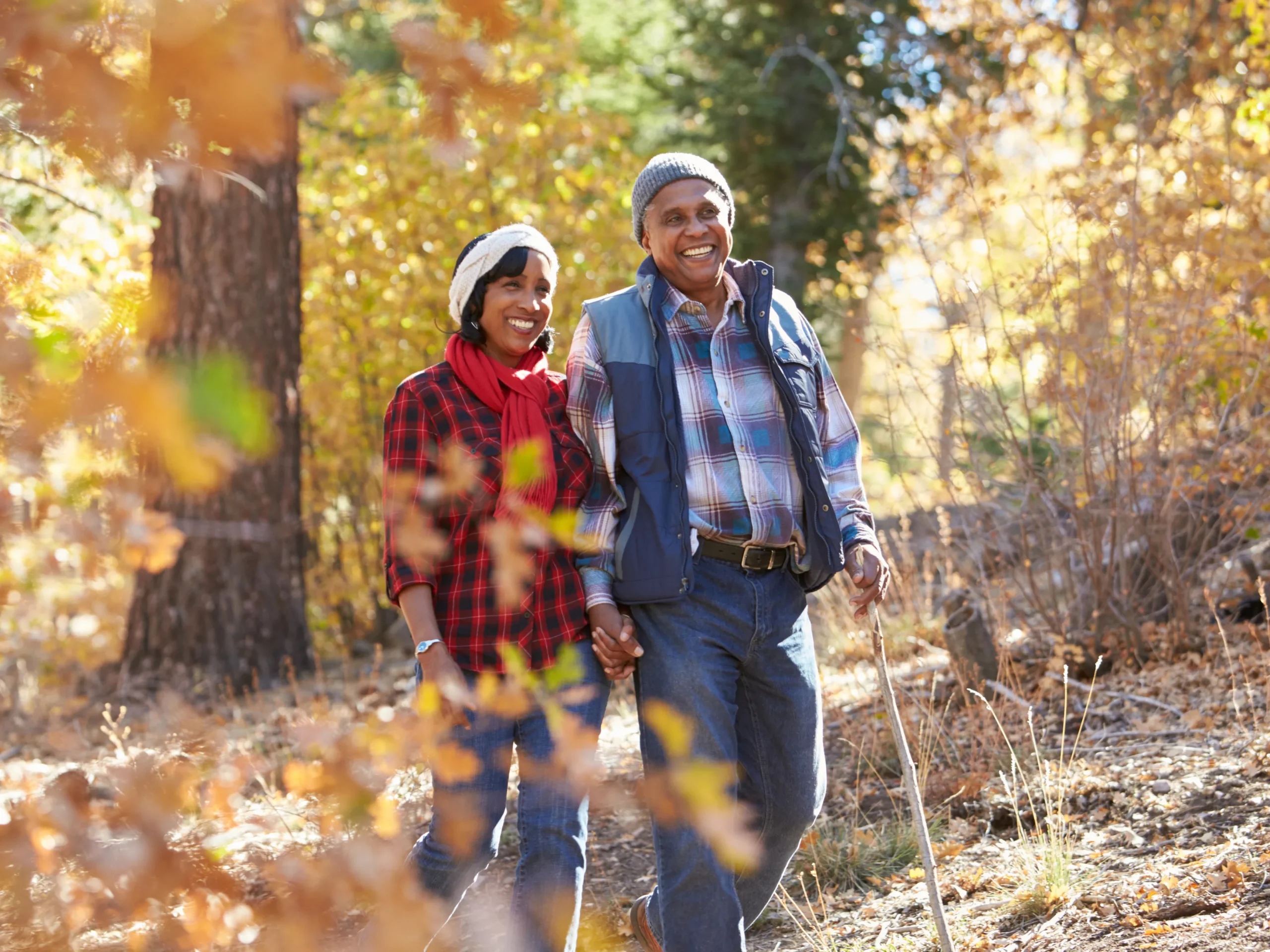 Couple enjoying fall activities for seniors walking in the woods
