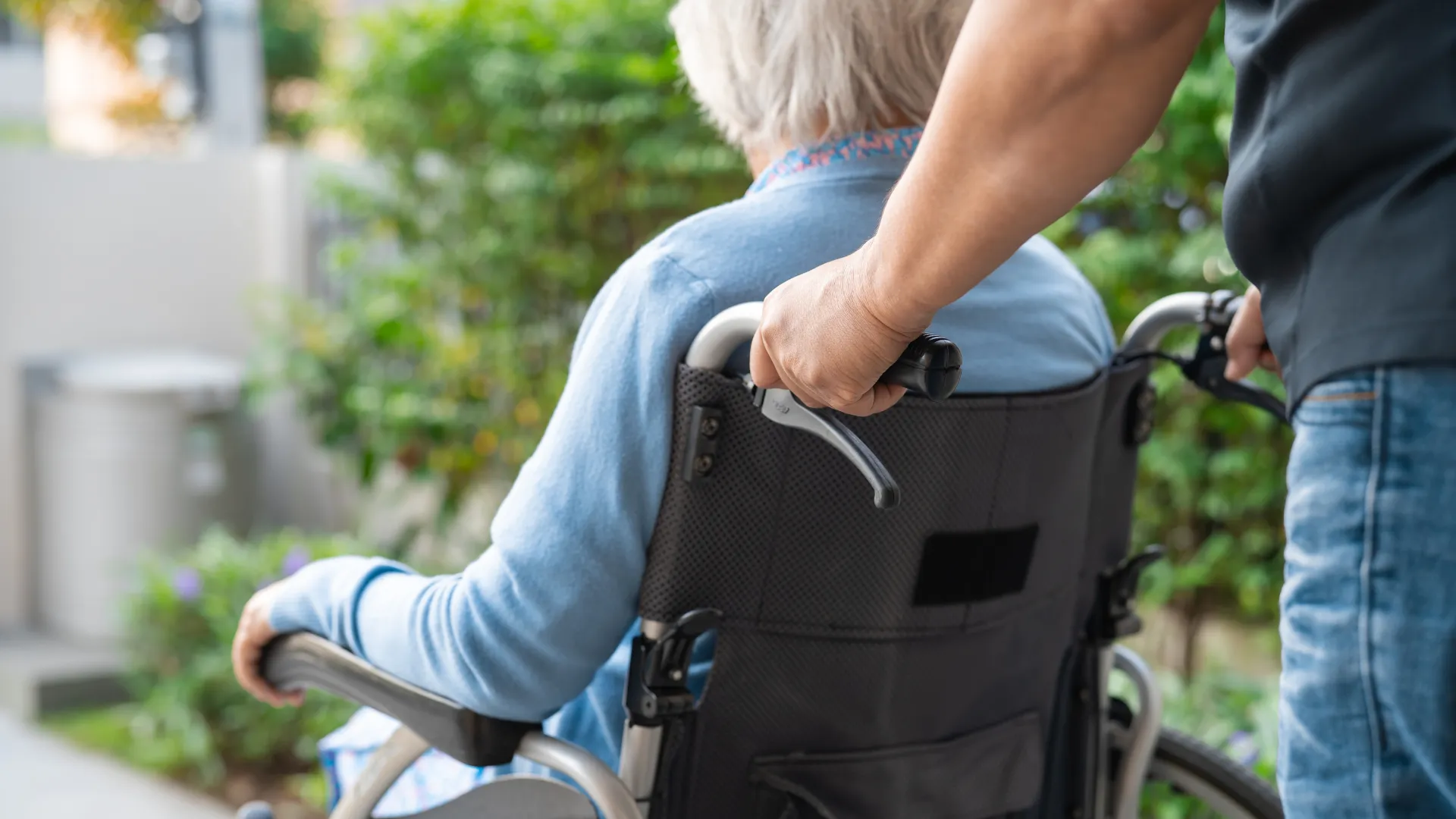 pushing an elderly person in a wheel chair